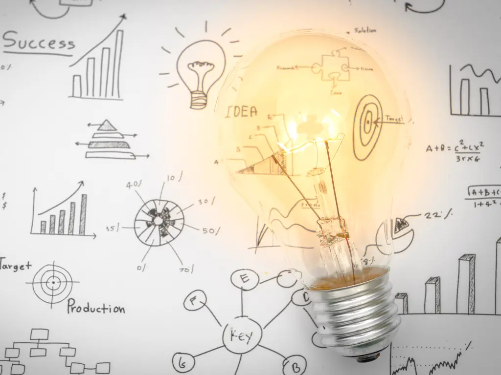 Light bulb shines on a wall filled with different ideas