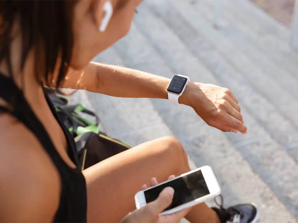Woman checks workout stats on smartwatch