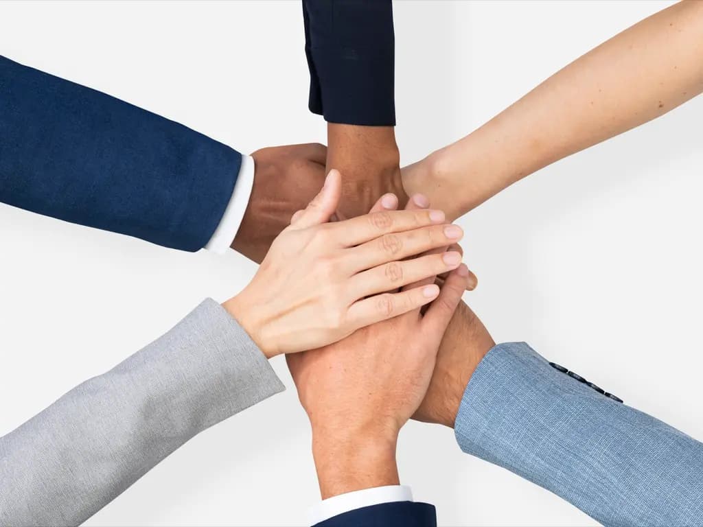A group of people put their hands one on top of the other